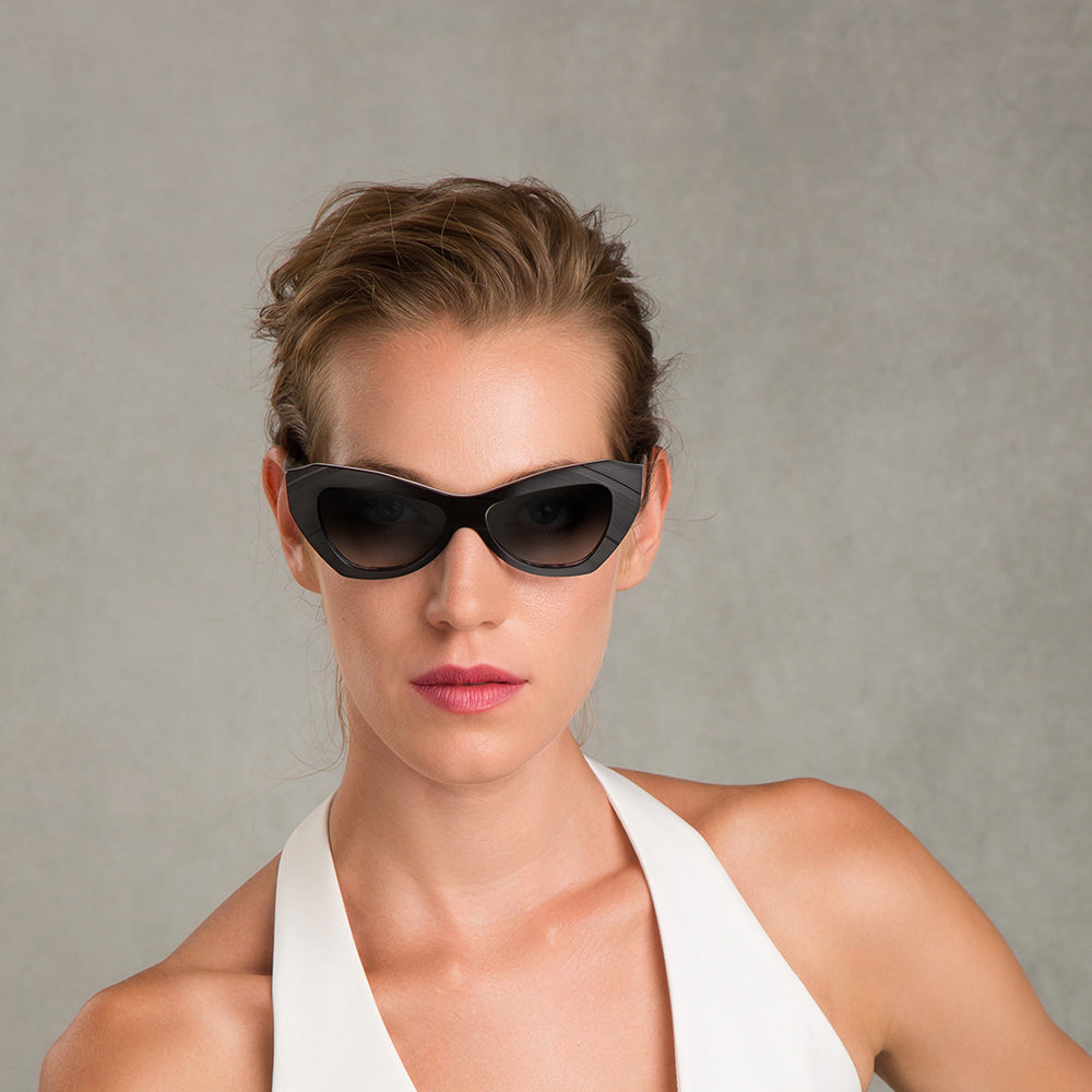 A pair of black, cat eye sunglasses with a thick frame.