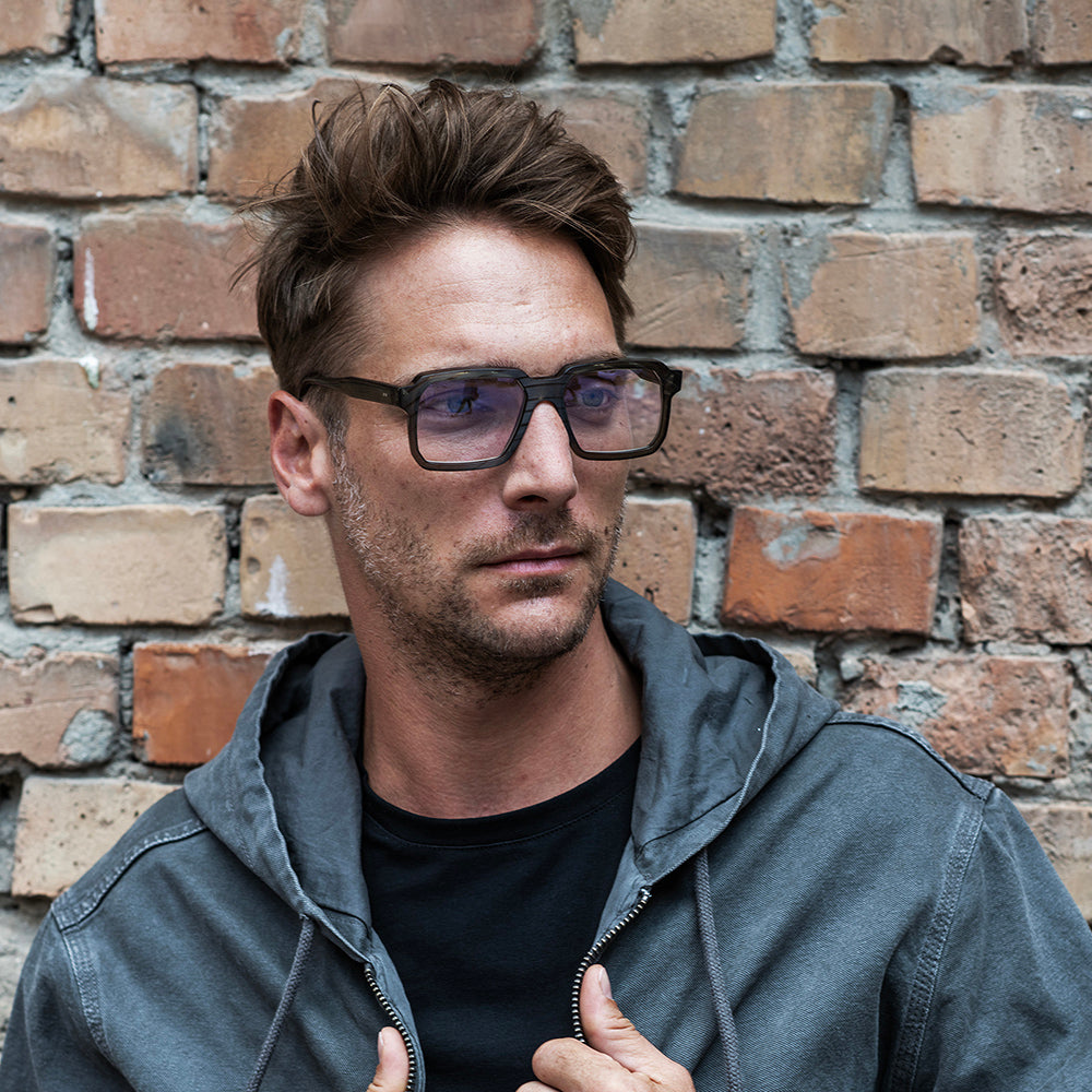 A pair of blue, square-framed eyeglasses with a record exterior design and a metallic hinge.