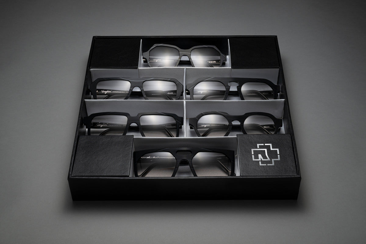 Set of eyeglasses in a black display box on a gray background